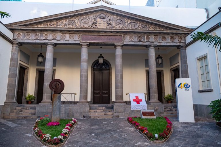 La fachada del Parlamento de Canarias luce la bandera de Cruz Roja y se iluminó el Día Mundial de la Cruz Roja