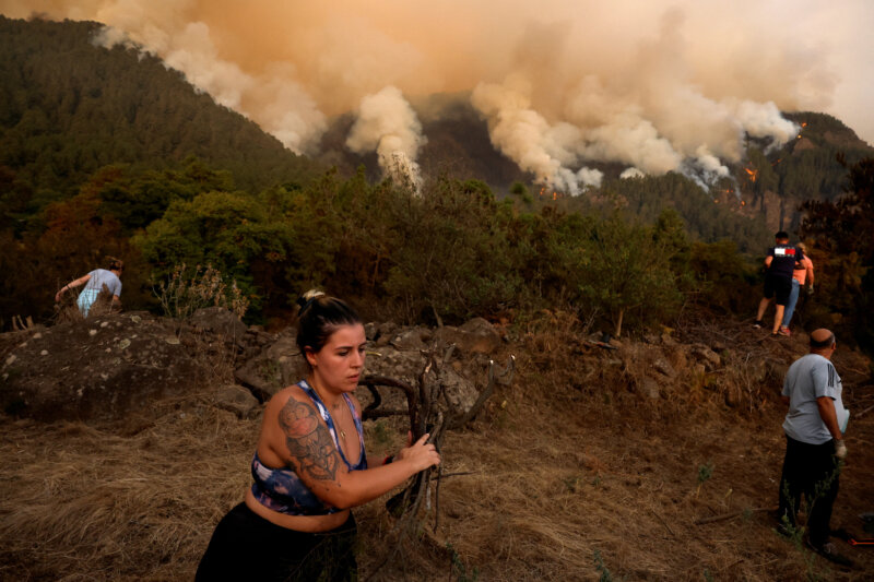 Los residentes de Aguamansa limpian los alrededores de sus casas debido a la proximidad del fuego. 17 de agosto de 2023. REUTERS/Borja Suárez