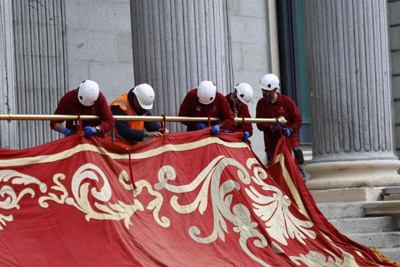 Operarios trabajan en la colocación del Baldaquino de Gala que volverá a adornar la fachada del Palacio del Congreso para la jura de la Constitución de la Princesa de Asturias, este lunes en Madrid. EFE/ Rodrigo Jiménez