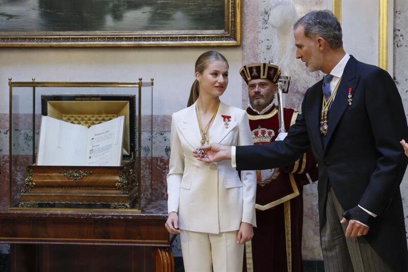 31/10/2023.- El rey Felipe VI ayuda a su hija, la princesa Leonor (c), tras serle impuestas a la heredera al trono las Medallas del Congreso y Senado en el escritorio del Congreso tras jurar la Constitución ante las Cortes Generales en el día de su 18 cumpleaños, este martes en el Congreso de los Diputados, en una ceremonia que representa el hito más importante de su trayectoria institucional y pavimenta el camino para que algún día se convierta en reina. EFE/Ballesteros POOL
