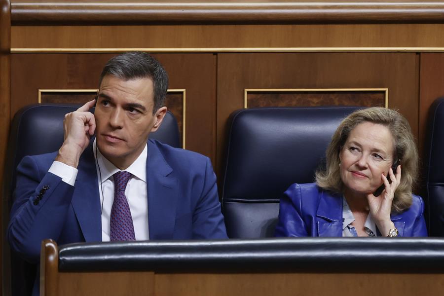 El secretario general del PSOE, Pedro Sánchez, y las vicepresidenta del Gobierno en funciones, Nadia Calviño con auriculares para la traducción simultánea durante la segunda jornada de la investidura celebrada en el Congreso. Sánchez, previsiblemente, logrará ser reelegido presidente del Gobierno tras superar la investidura con el apoyo de 179 diputados, este jueves en Madrid. EFE/ Juan Carlos Hidalgo
