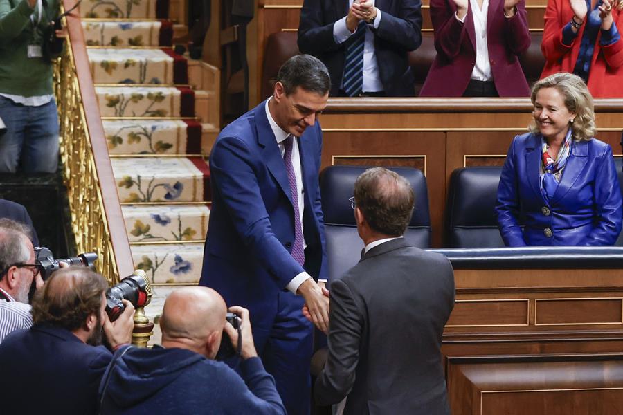 El líder del PP, Alberto Núñez Feijóo (d), felicita al presidente del Gobierno en funciones, Pedro Sánchez, al término de la segunda jornada del debate de investidura, este jueves en el Congreso de los Diputados en Madrid. Sánchez ha sido reelegido tras ser votado por 179 diputados tras pactar diferentes acuerdos con sus socios parlamentarios y una ley de amnistía para los encausados del 'procès'. EFE/ Juan Carlos Hidalgo