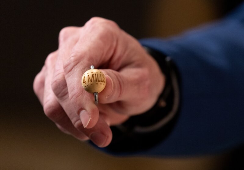 Un hombre enseña una bola con la cantidad de dinero de uno de los premios al inicio del Sorteo Extraordinario de la Lotería de Navidad 2023 en el Teatro Real de Madrid, a 22 de diciembre de 2023, en Madrid (España). Eduardo Parra / Europa Press 22/12/2023