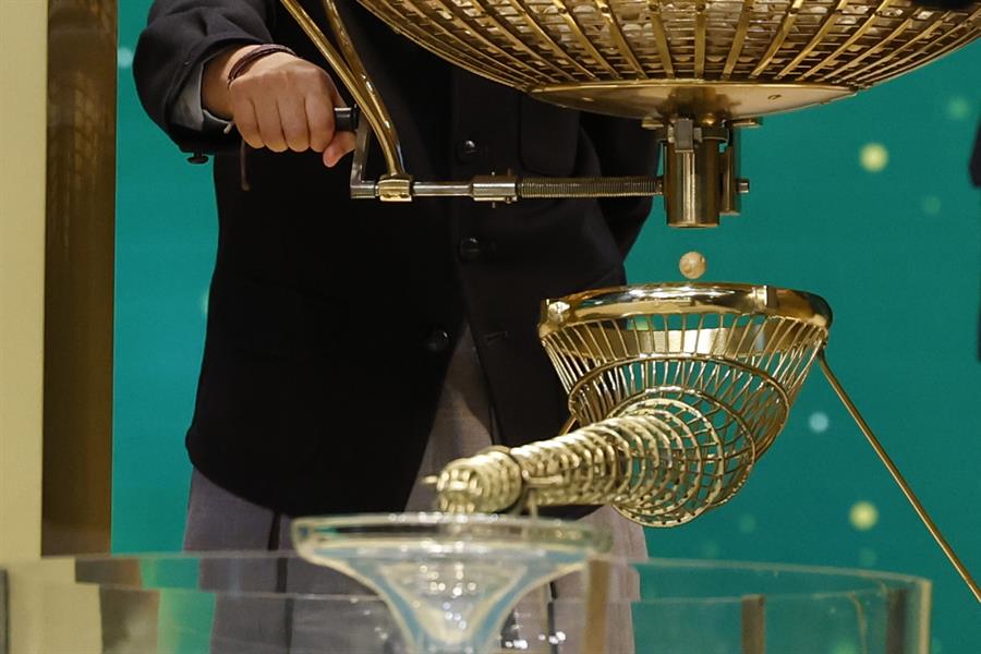 MADRID, 22/12/2023.- Uno de los niños de San Ildefonso saca las bolas de uno de los bombos durante el sorteo extraordinario de Navidad de la Lotería Nacional este viernes en el Teatro Real de Madrid. EFE/ J.J. Guillén