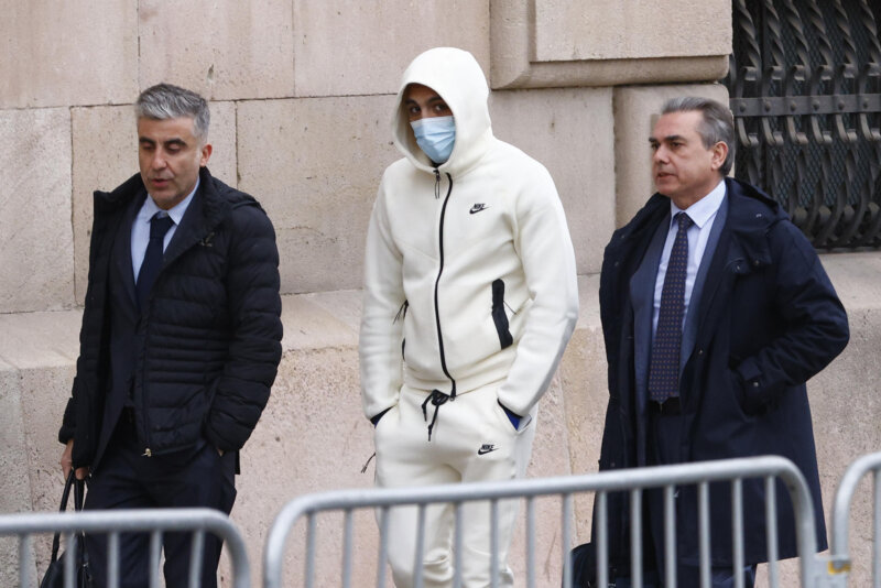 GRAFCAT560. BARCELONA, 28/02/2024.- El rapero Morad (c) llega a la Audiencia de Barcelona donde este miércoles se le juzga acusado de instigar a una multitud a lanzar piedras a los policías que en 2021 que actuaron ante las quejas vecinales por el ruido causado por la grabación, sin permiso, de un vídeo musical con un dron y para quien la Fiscalía pide siete años de cárcel. EFE/Quique García
