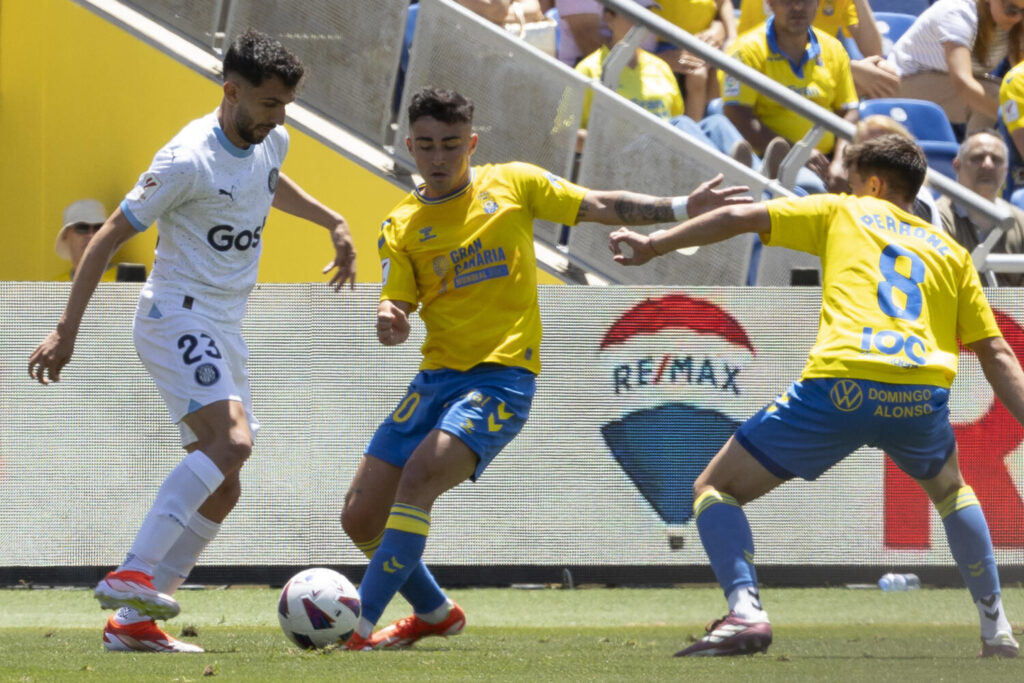 El centrocampista de la Unión Deportiva Las Palmas Alberto Moleiro, y el centrocampista del Girona Iván Martín, durante el partido de la jornada 33 de LaLiga EA Sports este sábado en el estadio de Gran Canaria .- EFE/Quique Curbelo
