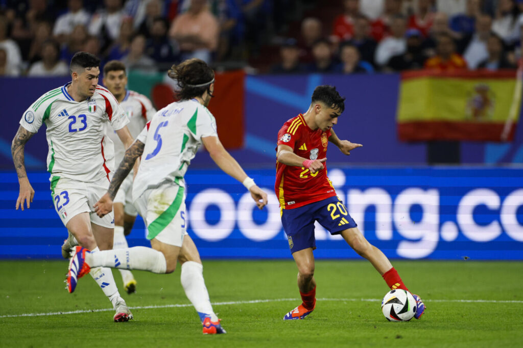 España - Georgia para los octavos de final de la Eurocopa GELSENKIRCHEN (ALEMANIA), 20/06/2024.- El centrocampista de la selección española, Pedri (d), golpea el balón ante los jugadores de selección italiana, Alessandor Bastoni (i) y Riccardo Calafiori, durante el encuentro correspondiente a la fase de grupos de la Eurocopa 2024 que España e Italia disputan hoy jueves en Gelsenkirchen (Alemania). EFE/Alberto Estévez.