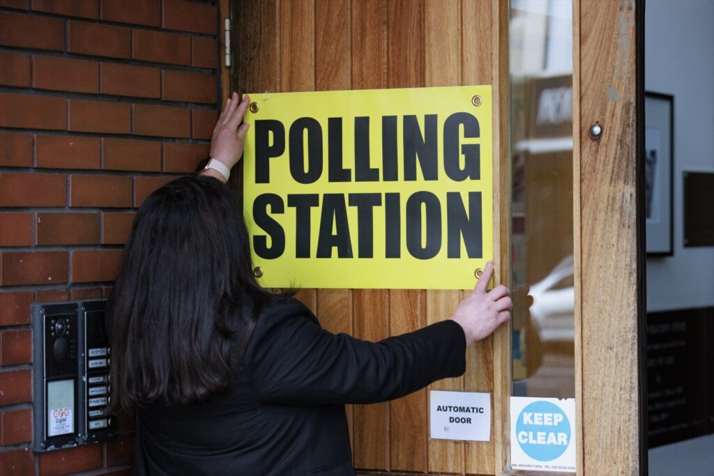 Reino Unido celebra elecciones 04 July 2024, United Kingdom, Belfast: A member of the polling station team at the Agape Centre in south Belfast hangs a sign ahead of polling stations opening in the UK 2024 General Election. Photo: Liam Mcburney/PA Wire/dpa 04/7/2024 ONLY FOR USE IN SPAIN