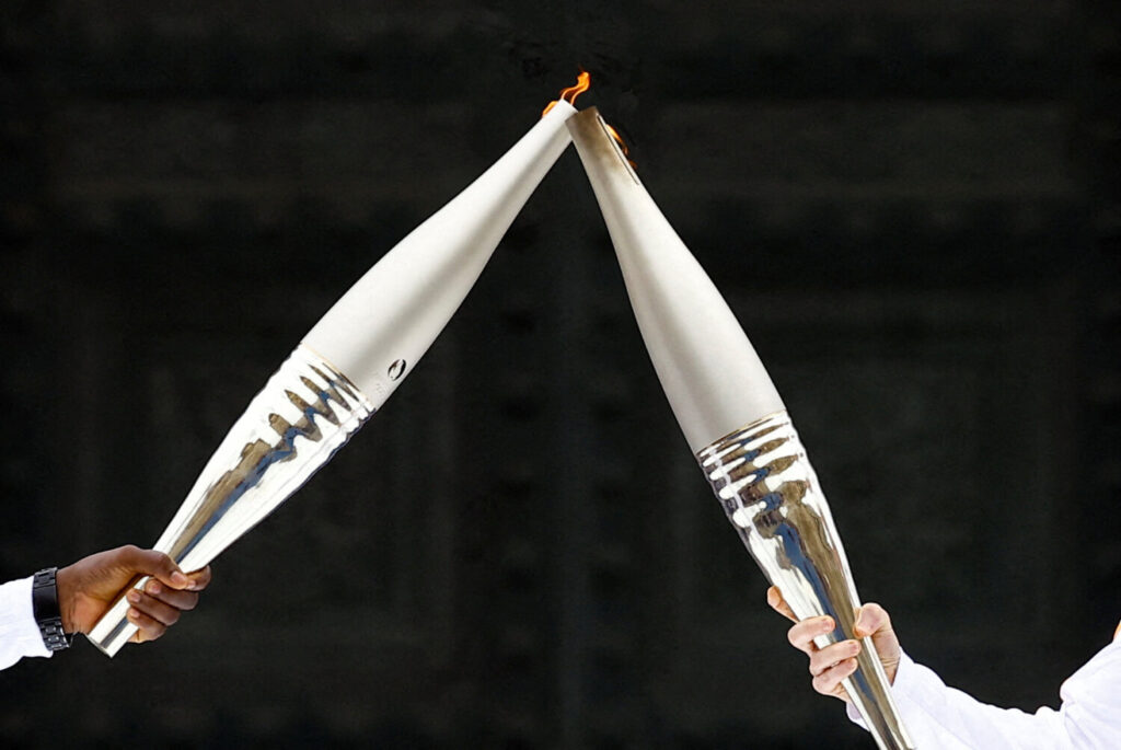 La Antorcha Olímpica es bienvenida en París. Claudine Laslaz y Lassana Bathily durante el relevo de la antorcha olímpica / / 14 de julio de 2024 / REUTERS / Christian Hartmann 