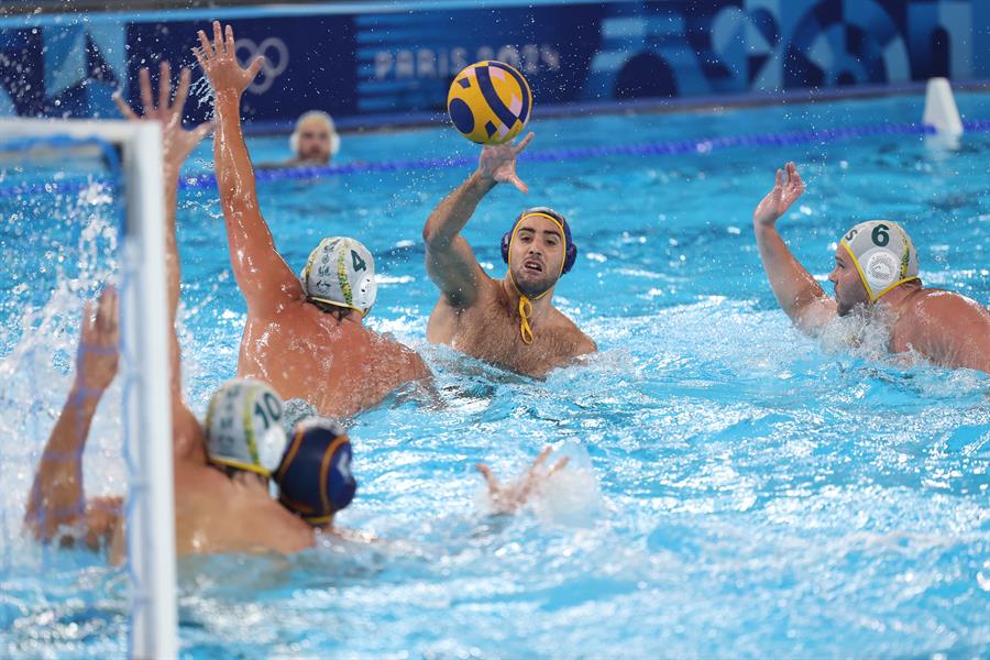 El jugador español Álvaro Granados (c) ante la defensa de los australianos Charlie Negus (c-i) y Lachlan Edwards (d) durante el partido de waterpolo que la selección española disputa contra Australia en el marco de los Juegos Olímpicos de París 2024, este domingo, en el Centro Acuático de París (Francia). España ganó 5-9. EFE/ Kiko Huesca