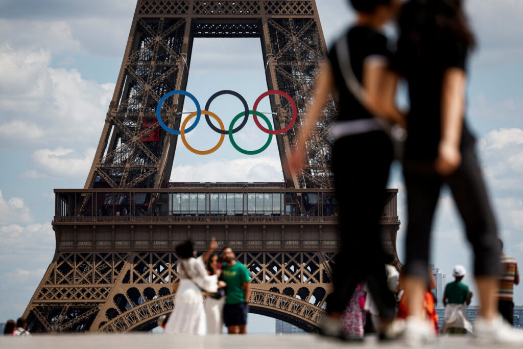 La gente camina en la plaza Trocadero mientras los anillos olímpicos se exhiben en la Torre Eiffel, antes de los Juegos Olímpicos y Paralímpicos de París 2024 en París, Francia, el 24 de junio de 2024. REUTERS/Benoit Tessier