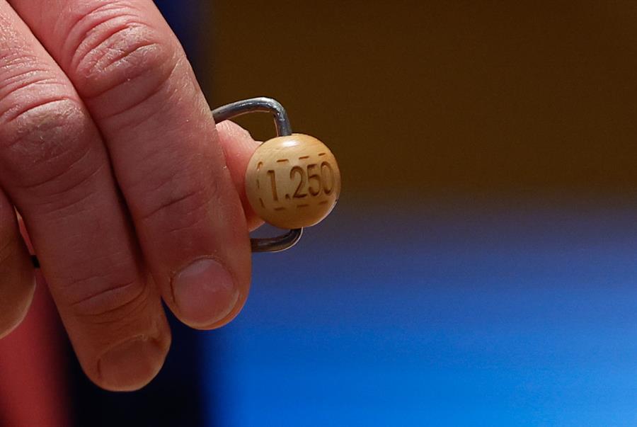 Un responsable enseña la bola de 1.250.000 euros del segundo premio antes de ser introducida en su respectivo bombo durante preparativos para el sorteo de la Lotería de Navidad este domingo en el Teatro Real, en Madrid. EFE/Javier Lizón