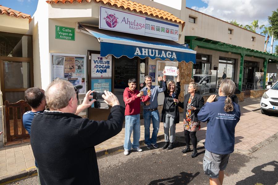 El dueño del bazar Ahulaga de Antigua (Fuerteventura), Jesús Cubas (2i), brinda con sus empleados y familiares tras haber repartido parte del cuarto premio del número 77.768 del sorteo extraordinario de Navidad de la Lotería Nacional. Es el primer premio importante que da esta administración desde que Cubas se convirtió en su bpropietario hace solo unos meses. EFE/ Carlos De Saá