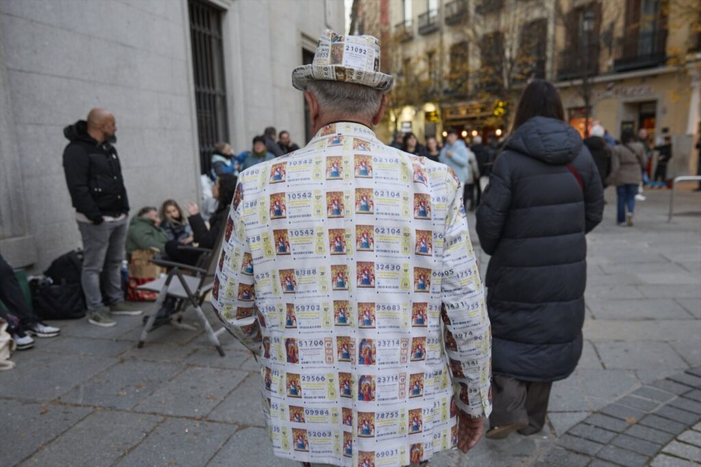 Hay personas que viven con tradición este día antes. Este señor se prepara cada año un traje confeccionado con la imagen de los décimos. / Europa Press