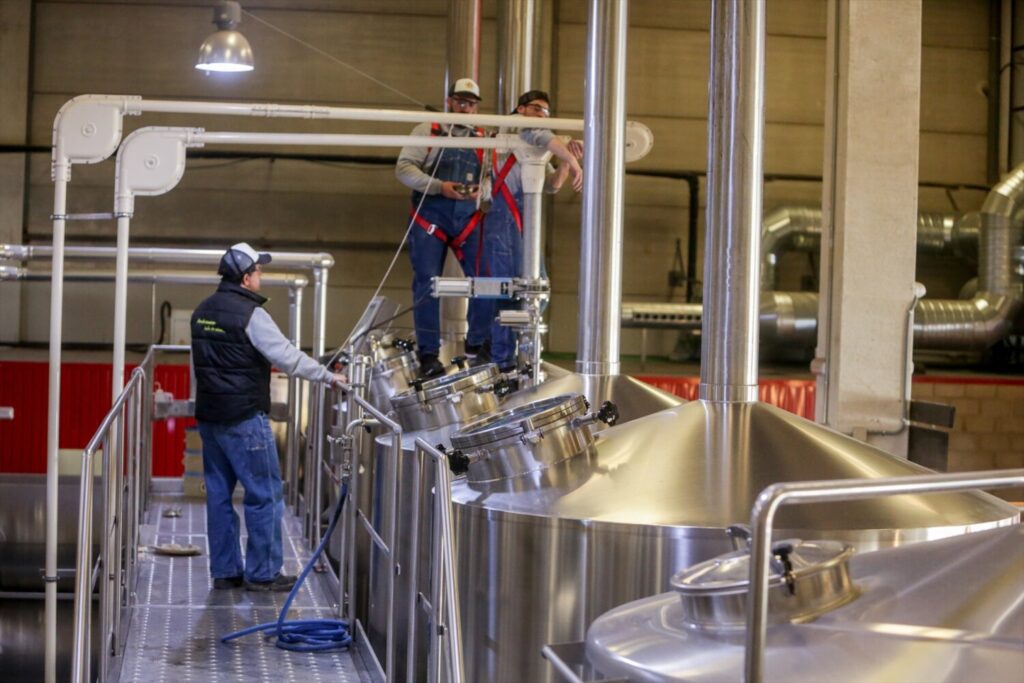 Los precios industriales en Canarias aumentan un 48,9% en febrero. (ARCHIVO) Operarios trabajando entre alambiques en la fábrica de cerveza artesanal 'La Virgen', en Las Rozas (Madrid, España), a 9 de noviembre de 2019. Ricardo Rubio/ Europa Press.
