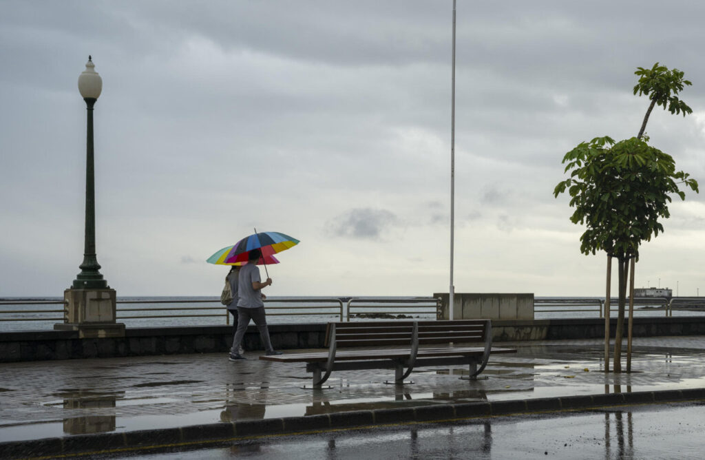 La borrasca 'Olivier' ha dejado lluvias fuertes en toda la isla de Lanzarote. En la imagen dos personas pasean por Arrecife. EFE/Adriel Perdomo.