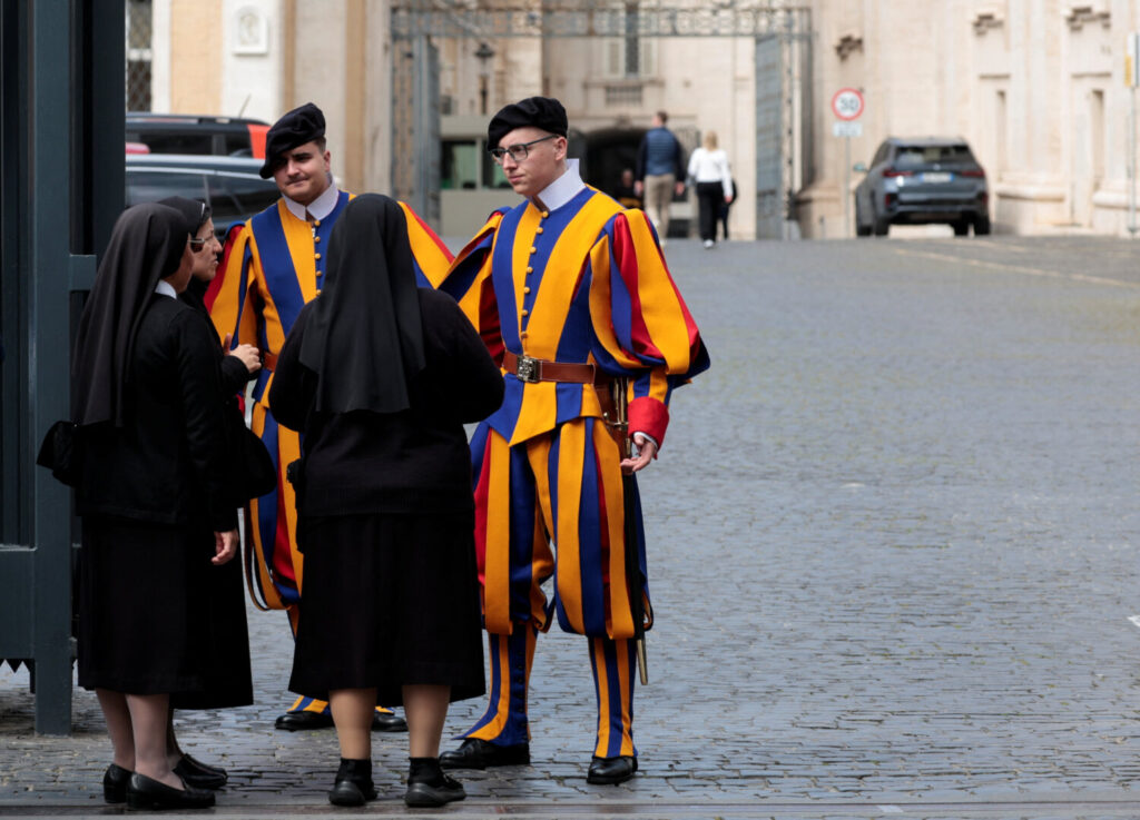 Guardias suizos hablan con monjas mientras patrullan cerca de una de las entradas del Vaticano, luego de que el Vaticano anunciara la muerte del Papa Francisco en un comunicado en video, visto desde Roma, Italia, el 21 de abril de 2025. REUTERS/Remo Casilli