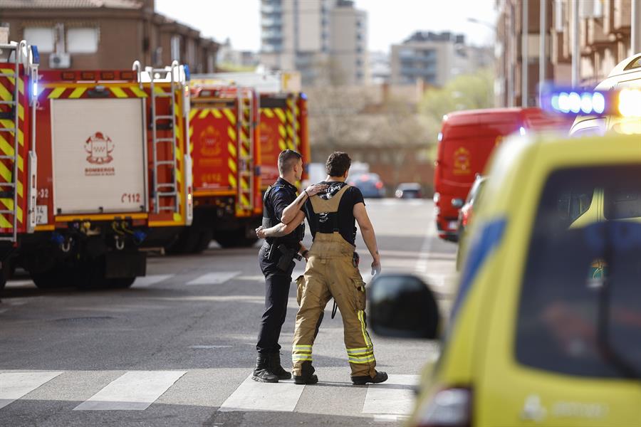 Agentes de la policía acompañan a un bombero en las inmediaciones del garaje de Alcorcón (Madrid) donde este miércoles se ha originado un incendio causando la muerte a dos bomberos, y otros cinco han resultado heridos por inhalación de humo. EFE/ Rodrigo Jimenez