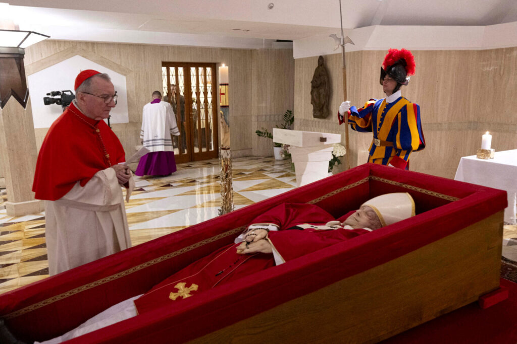 El cardenal Pietro Parolin, secretario de Estado del Vaticano, permanece junto al cuerpo del papa Francisco, colocado en un ataúd abierto durante el rito de la declaración de muerte en la residencia de Santa Marta, en el Vaticano, el 21 de abril de 2025. Prensa del Vaticano/Folleto vía REUTERS