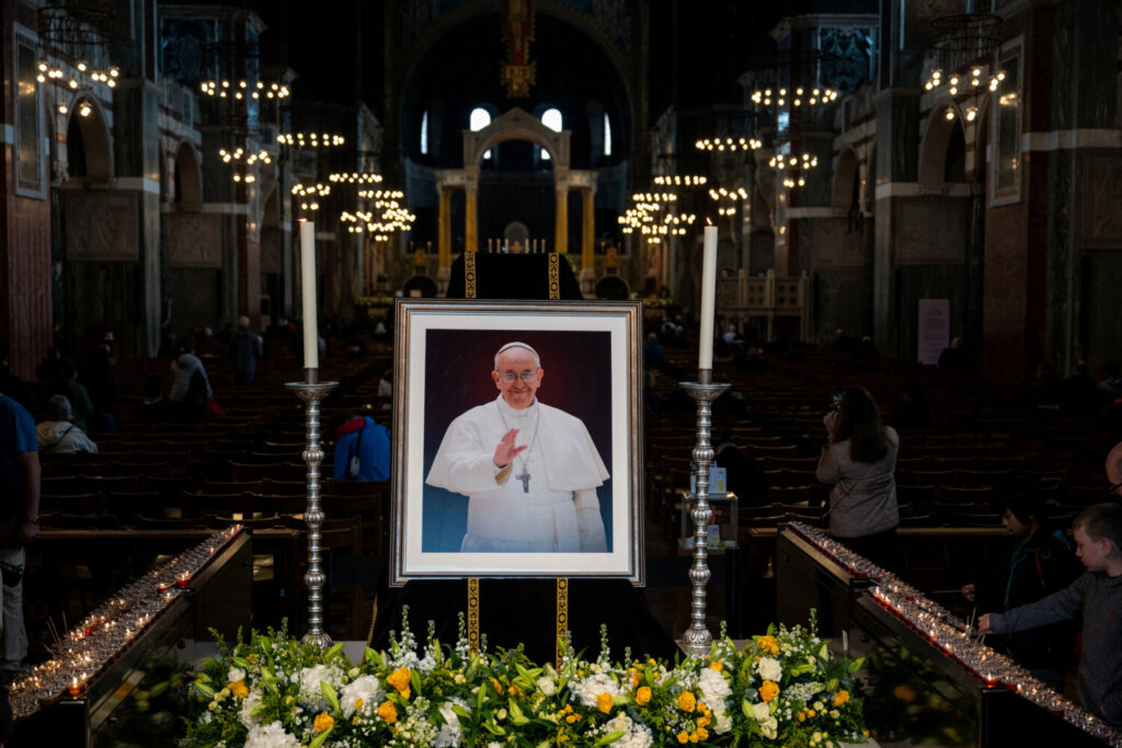 Los católicos rezan frente a un retrato del Papa Francisco en la Catedral Metropolitana de la Preciosísima Sangre, conocida informalmente como la Catedral de Westminster, tras la noticia de su muerte, en Londres, Gran Bretaña, el 21 de abril de 2025. REUTERS/Chris J. Ratcliffe