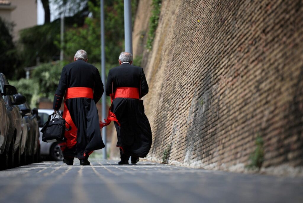 Dos sacerdotes caminando de espaldas en el Vaticano