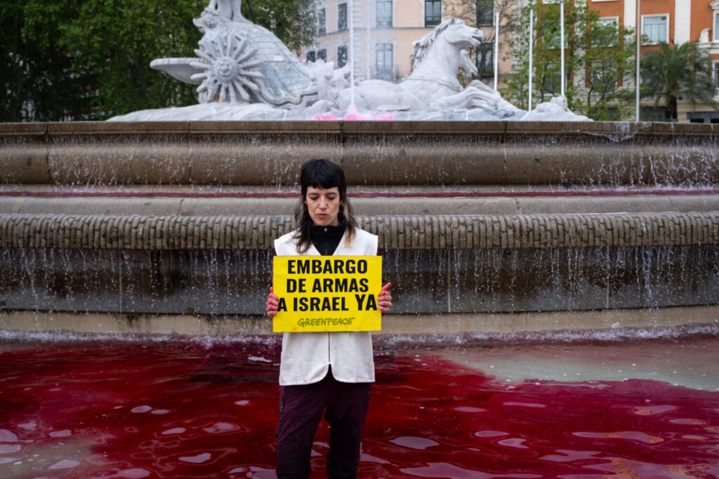 Una activista de Greenpeace denuncia en la fuente de Neptuno el genocidio en Palestina por parte de Israel