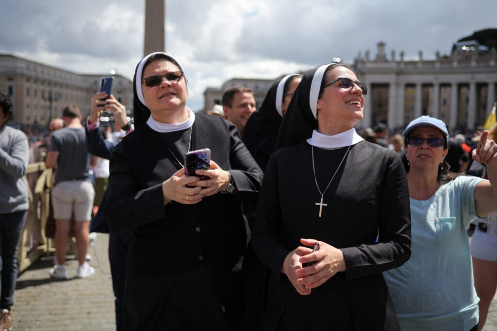 Unas monjas miran hacia la chimenea desde la plaza de San Pedro. REUTERS/Marko Djurica
