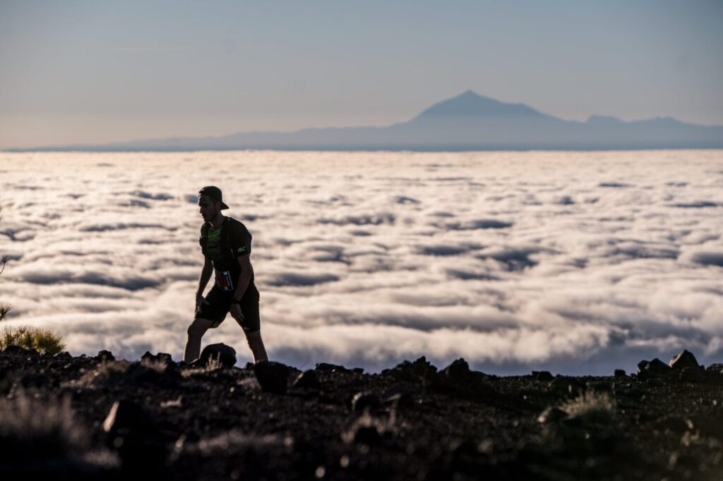 Imagen de archivo de un atleta sobre un mar de nubes y el Teide de fondo