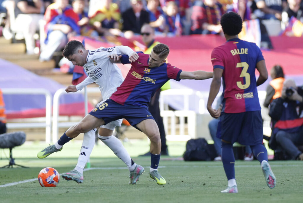 BARCELONA, 11/05/2025.- El centrocampista del FC Barcelona, Fermín López (d), disputa el balón ante el centrocampista uruguayo del Real Madrid, Federico Valverde, durante el partido de la jornada 35 de LaLiga EA Sports entre el Barcelona y el Real Madrid, este domingo en el Estadi Olímpic Lluís Companys. EFE / Alberto Estevez.