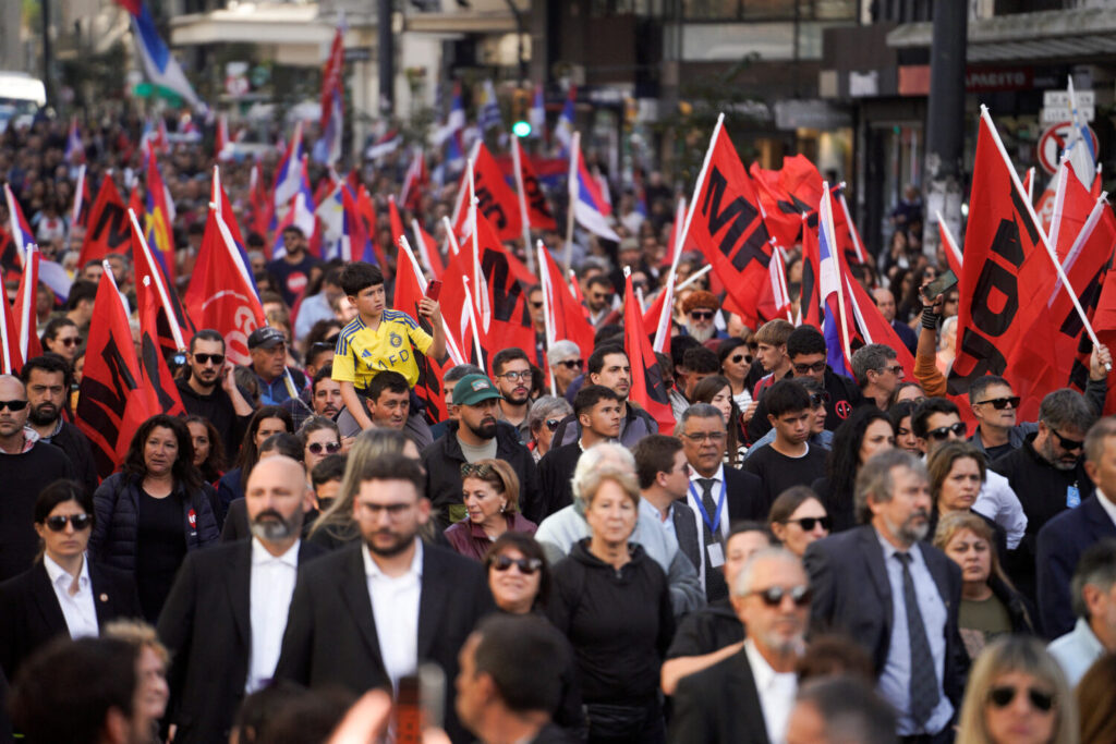 Simpatizantes del Movimiento de Participación Popular (MPP) sostienen banderas el día que el coche fúnebre que transporta el cuerpo del expresidente uruguayo José "Pepe" Mujica se dirige al Palacio Legislativo, en Montevideo, Uruguay, el 14 de mayo de 2025. REUTERS/Andrés Cuenca