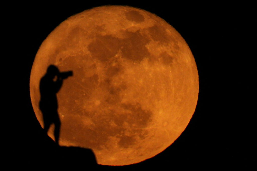 Así se vio ‘luna de fresa’ desde Canarias. Un fotógrafo se siluetea contra la luna llena conocida como luna de fresa en Arinaga (Gran Canaria), 11 de junio de 2025. REUTERS/Borja Suárez