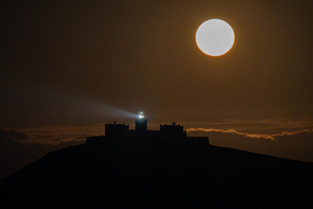 TUINEJE (FUERTEVENTURA), 12/06/2025.- La luna de fresa esta noche junto al Faro de la Entallada. Esta primera luna llena de junio coincide con un fenómeno astronómico poco común, el lunasticio, fenómeno por el cual el astro alcanza la inclinación más extrema dentro de su órbita, y no se volverá a repetir hasta el año 2043. EFE/Carlos de Saá