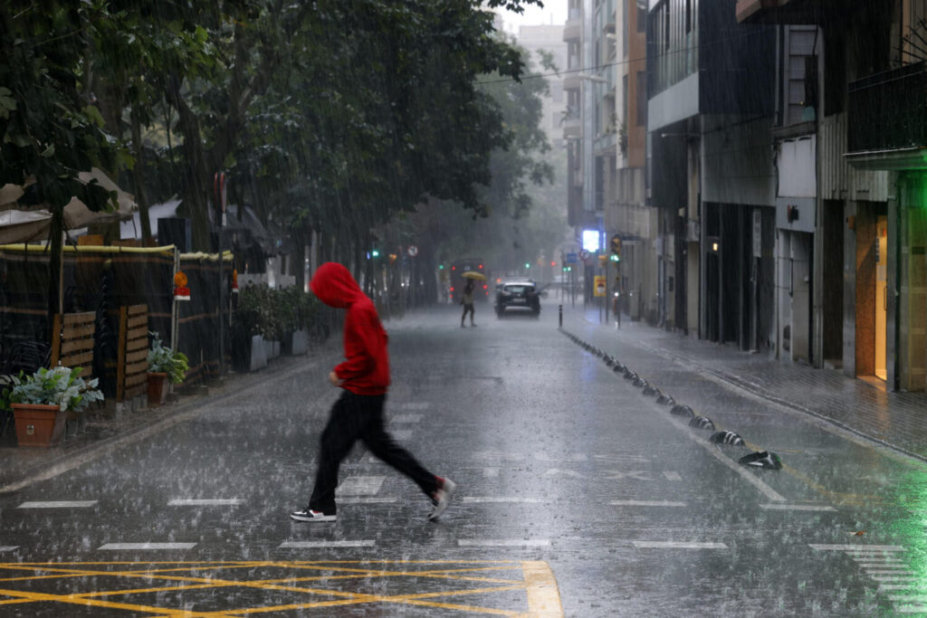 Alerta roja por lluvias torrenciales en Cataluña y Valencia, donde suspenden las clases mañana lunes. Arriba, imagen de archivo de lluvias en Barcelona. EFE
