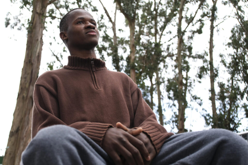 El joven guineano Habib Camara, uno de los supervivientes del cayuco que volcó a finales del mes de mayo en el puerto de La Restinga en la isla de El Hierro, durante una entrevista para contar su experiencia por fuera de las instalaciones Centro de Primeras Llegadas Las Raíces en Tenerife. EFE/Alberto Valdés