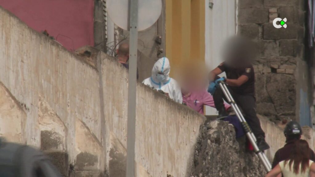 El joven investigado presuntamente por quemar a la menor, en la imagen, con mono blanco, llegó a la vivienda en La Isleta, con el rostro totalmente cubierto. RTVC.