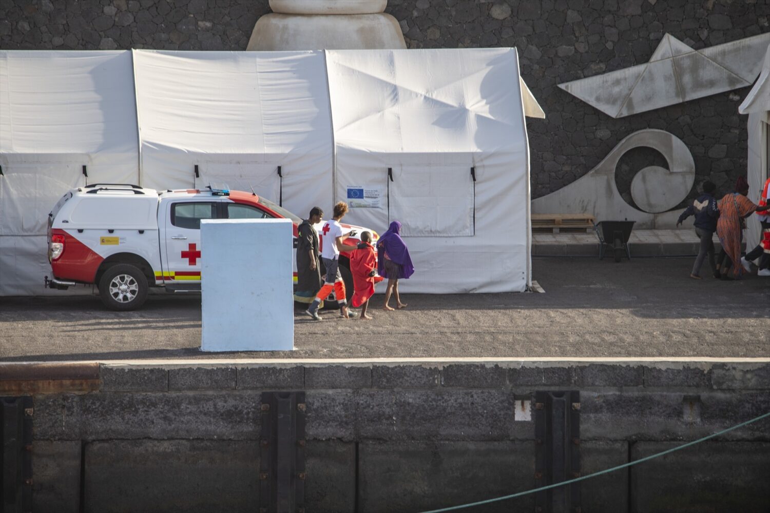 Salen de Canarias los tres primeros menores tras la declaración de contingencia migratoria. Imagen de archivo de agentes de los Servicios de Emergencias atendiendo menores migrantes a su llegada al Puerto de la Restinga, en El Hierro. Antonio Sempere / Europa Press