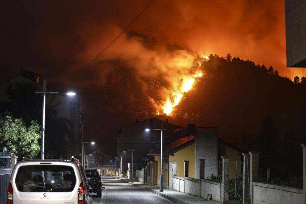 Más de 40 incendios continúan activos y arrasan Cáceres, Ourense y Castilla y León. En la imagen de arriba, vista de esta madrugada de las llamas en Vilamartin de Valdeorras y O Barco de Valdeorras mientras continúa activo el incendio forestal de A Rúa (Ourense). EFE/Sxenick