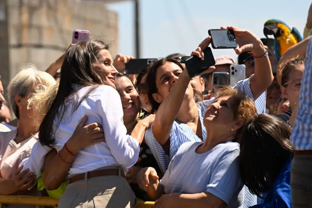 La reina Letizia posa para una foto con un grupo de vecinos mientras los reyes visitan la parroquia de Medieros, en Monterrei (Ourense), donde se han reunido con una representación de vecinos afectados por los incendios