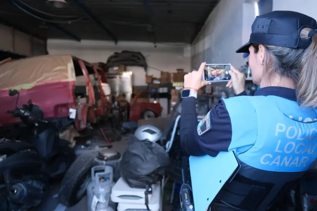 Una agente de la policía local toma fotografías en uno de los talleres denunciados