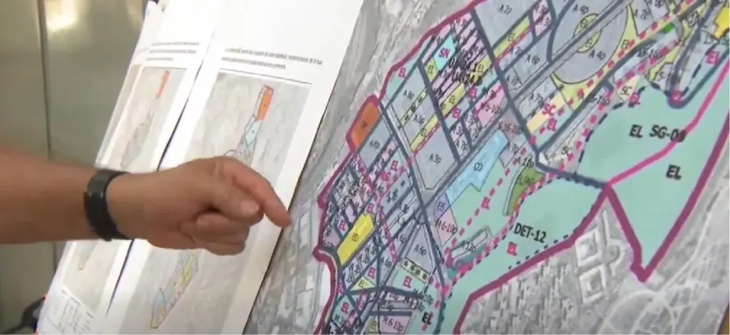 Un vecino señala el plano del barrio de Las Torres en protesta por lo que creen que será un plan de desahucios