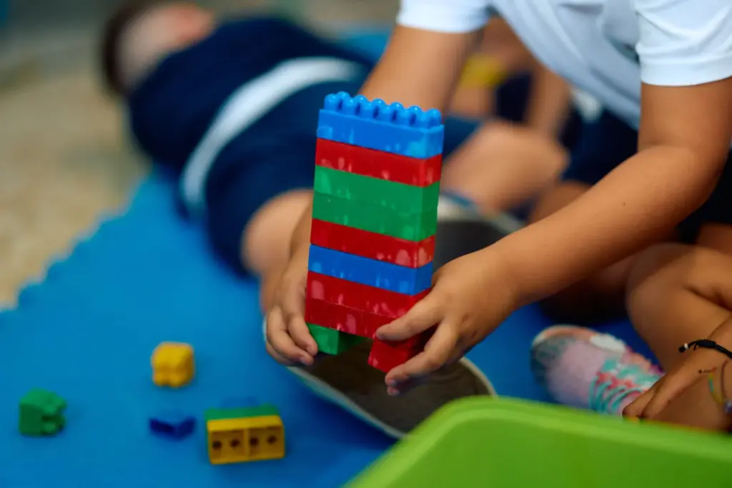 Imagen de archivo de un niño jugando con unos legos en un aula