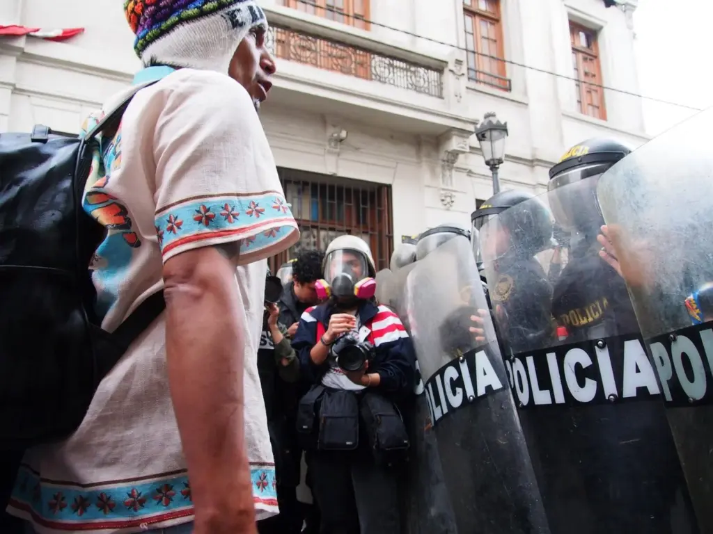 Al menos un muerto y más de cien heridos, incluidos 80 policías, en las protestas antigubernamentales en Lima. En la imagen, un joven manifestante frente a un pelotón de Policía en Lima. Europa Press/Carlos Garcia Granthon
