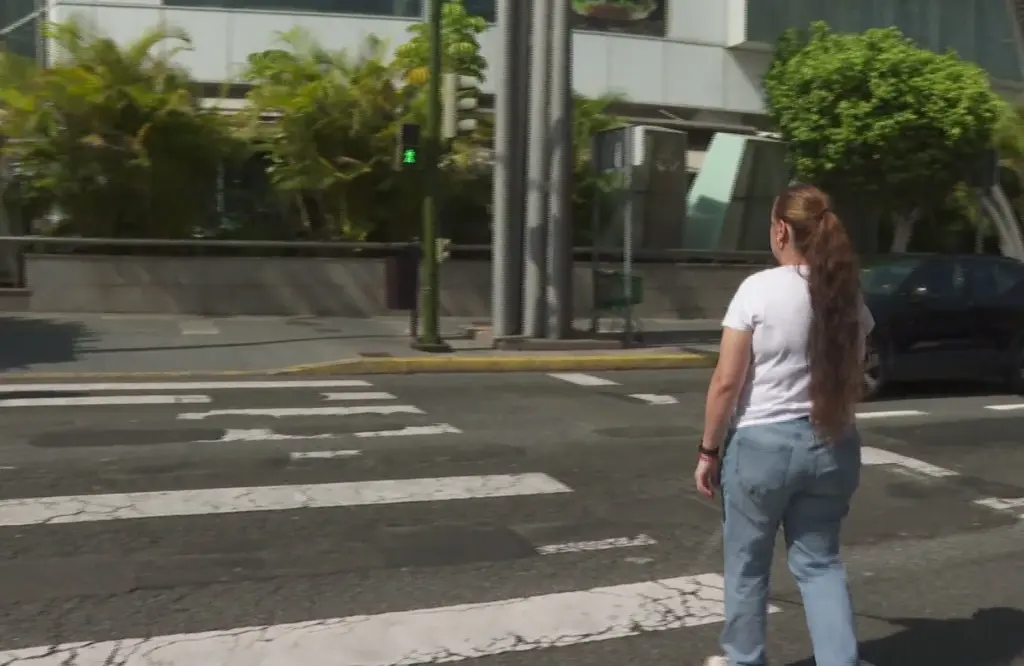 Una persona con discapacidad visual cruza en un paso de peatones