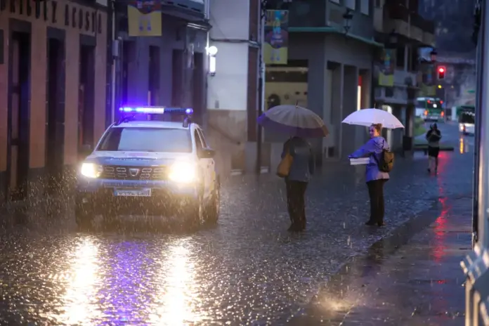 GRAFCAN6744. SANTA CRUZ DE LA PALMA (ESPAÑA), 12/11/2025.- La borrasca Claudia está deja lluvias intensas y fuertes rachas de viento en La Palma, especialmente en el noroeste y centro de la isla. Hasta las 18.00 horas se han registrado 90 litros por metro cuadrado en el Roque de los Muchachos, 69 en El Paso y 42 en Puntagorda, según la Aemet. En la imagen, varias personas se protegen del aguacero en Santa Cruz de La Palma. EFE/Luis G. Morera