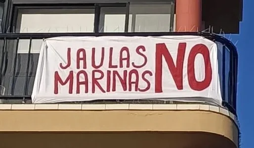 Uno de los carteles de protesta en el litoral de Telde contra las jaulas marinas instaladas en la zona