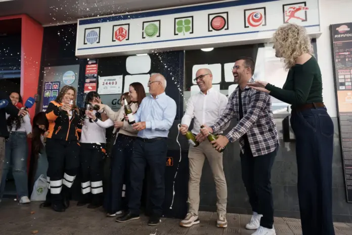 Empleados y propietarios de la administración de lotería situada en la estación de servicio La Chasnera, en el municipio tinerfeño de Granadilla de Abona, en la que ha caído el tercer premio de la Lotería de Navidad. EFE/Ramón de la Rocha