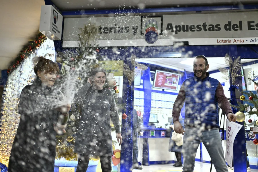 El número 25.508 ha sido agraciado con el segundo de los cuartos premios del sorteo de la Lotería de Navidad de este lunes, dotado con 200.000 euros a la serie (20.000 euros al décimo). En la imagen, empleados de una administración de lotería de Ourense donde ha sido vendido dicho número. EFE/Brais Lorenzo