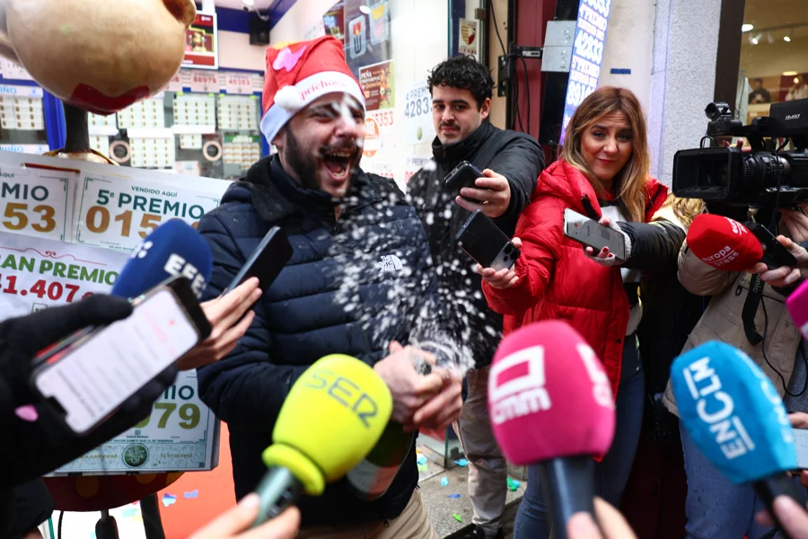 Varias personas celebran a las puertas de una administración de lotería este lunes en Toledo, donde se ha vendido el número 78.477, que ha sido agraciado con un cuarto premio en el Sorteo de la Lotería de Navidad y dotado con 200.000 euros a la serie (20.000 euros al décimo).- EFE/ Ismael Herrero