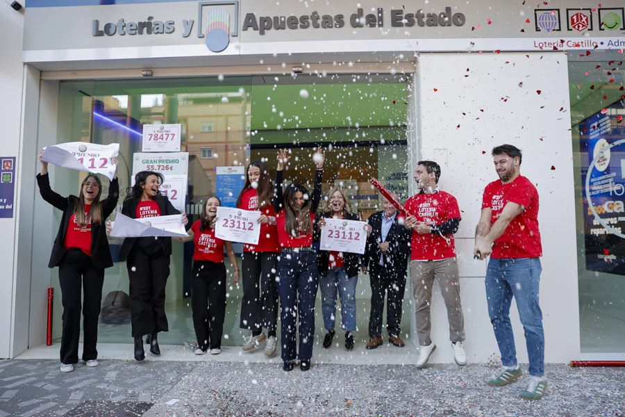 Los trabajadores de la administración de lotería Castillo de Alaquàs celebran la venta de una serie del cuarto premio 78.477 y una del quinto premio 23.112 de la lotería de Navidad. EFE/Manuel Bruque