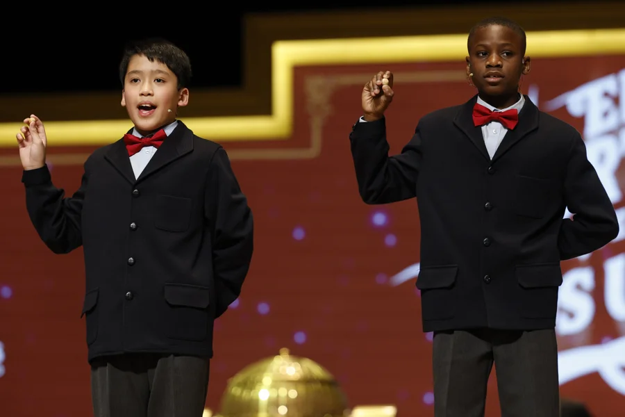 Los niños de la Residencia San Ildefonso del Ayuntamiento de Madrid Agustín Nicanor Bikoro (i) y Axiel Kyron Abas Limbaga (d) cantan los números de la sexta tabla durante el Sorteo Extraordinario de Navidad celebrado este lunes en el Teatro Real. EFE/Chema Moya
